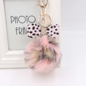Leopard print pom pom keychain with pink bow and crystal accent on a gold-tone keyring