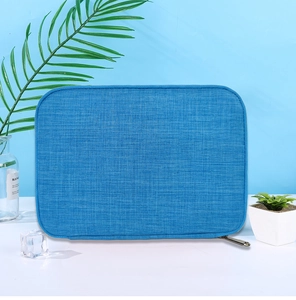 Blue textured fabric watch strap organizer bag with zipper closure on a white desk