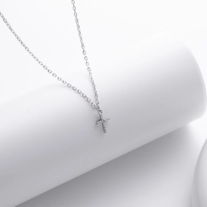 Elegant S925 sterling silver cross pendant necklace with clear diamonds on white stand