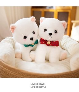 Close-up of two white plush Pomeranian puppies in a basket with polka dot bows