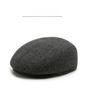 Close-up of grey wool blend fabric texture and stitching on men's winter ivy cap