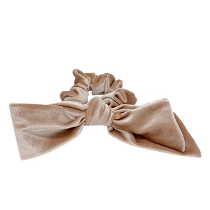 Elegant beige velvet scrunchie with large bow and gold charm in a clean studio shot