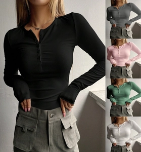 Detail of ribbed knit slim fit top featuring a row of buttons on the crew neck