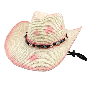 Detail of western straw hat featuring pink stars, turquoise beads, and wooden trim