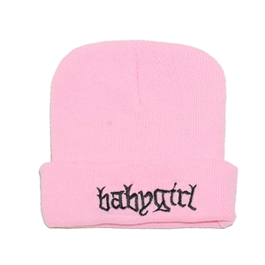 Dettaglio del ricamo Babygirl su un berretto invernale in maglia a coste rosa