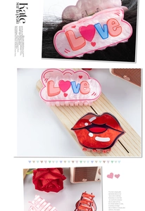 Detail of pink LOVE heart hair claw and red lip-shaped clip on stylish long dark hair
