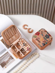 Macro detail of portable cork jewelry box with floral prints and velvet ring slots