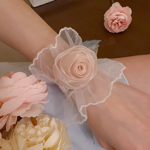 Vue détaillée d'un bracelet rose en dentelle et tulle avec fleur de rose élégante