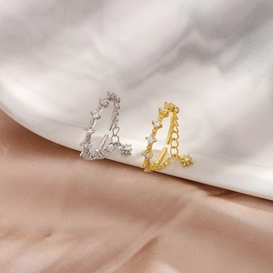 Detailed macro view of gold and silver double-layer rings with star charms and zirconia