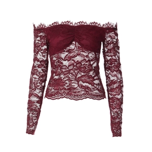 Dettaglio del top in pizzo bordeaux con spalle scoperte e ricami floreali intricati
