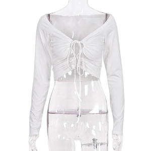 Dettaglio crop top bianco a maniche lunghe con lacci regolabili e scollo a V