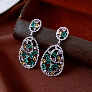 Detailed close-up of oval zircon pendant earrings with green and purple gemstones