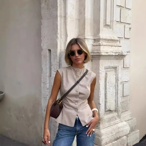 Gilet beige a scacchi con bottoni frontali in un servizio fotografico street style professionale