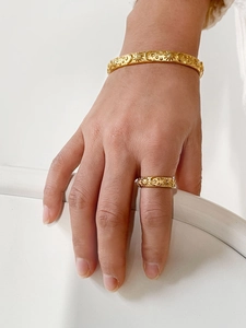 Detailed close-up of golden celestial jewelry set with engraved sun moon and star patterns