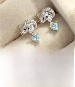 Detail of silver cat-shaped stud earring featuring a blue heart-shaped cubic zirconia stone