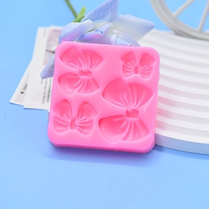 Rosa Silikonform mit vier verschiedenen Schleifenformen für Fondant und Kuchendekoration