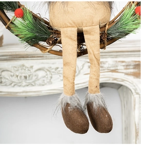 Detail of plush elk on grapevine Christmas wreath with pine needles and rustic finish