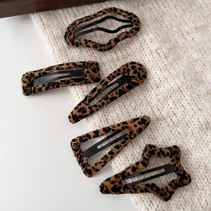 5-piece vintage leopard print hair clips in various geometric shapes on a warm beige fabric