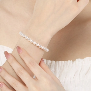 Close-up of elegant white round pearl bracelet on wrist with minimalist chic design
