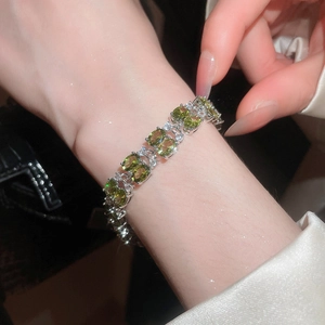 Detail shot of silver finish bracelet with oval green stones and white pavé accents