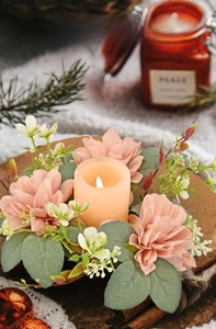 Close-up of pink dahlia candle ring with realistic green leaves for table decor