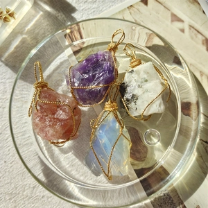 Four natural raw crystal pendants in purple, pink, and white with 18K gold wire wrapping