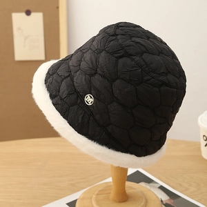 Quilted black bucket hat with white faux fur trim and gold 'M' metal badge
