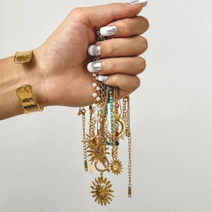Gold layered necklace with sun pendants, pearls, turquoise beads and wide hammered cuff bracelet