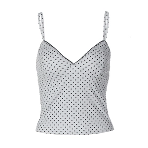 Detail of V-neck white polka dot camisole with slim straps and sleek stretch fabric