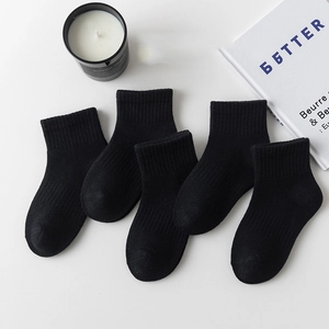 Five pairs of kids black cotton crew socks for school sports on white background