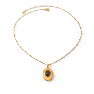 Primer plano de un collar vintage chapado en oro de 18 quilates con colgante de ojo de tigre