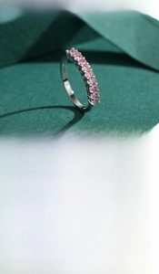 Close-up of S925 sterling silver ring featuring a row of eleven pink zircon gemstones
