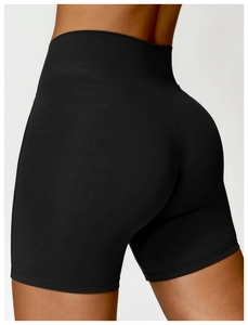 Side view of high-waisted seamless black yoga shorts with ergonomic stitching on female model