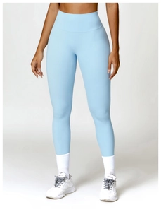 Detail of high-waist yoga leggings in light blue with white sneakers and sport socks