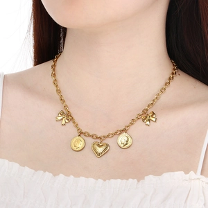 Detail of gold-plated double-layer necklace with coin, heart, and bow pendants