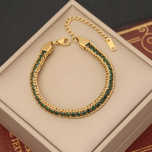 Close-up of gold-plated woven chain bracelet with green crystals and 18KGP stamp