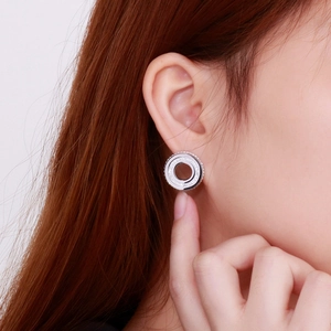 Close-up of elegant silver round stud earrings with shimmering pave crystals on model