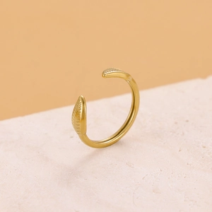 Detailed shot of gold stainless steel open ring with textured tips on a beige stone