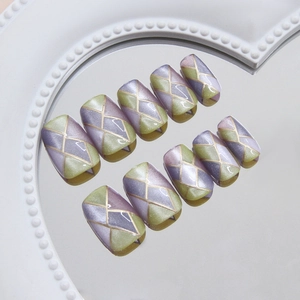 Cat eye press on nails with purple and green geometric patterns and gold trim