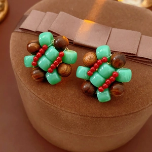 Close-up of ethnic resin beaded earrings with green square and brown round wood beads