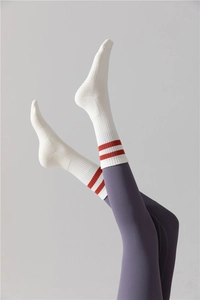Détail de chaussettes de yoga blanches à rayures rouges avec semelles antidérapantes