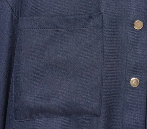Détail du tissu sergé bleu marine et des boutons en métal doré sur la poche de veste