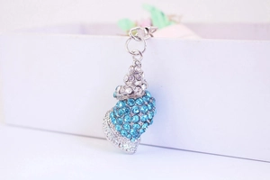 Macro shot of seashell keychain with sparkling blue and white rhinestones and metal ring
