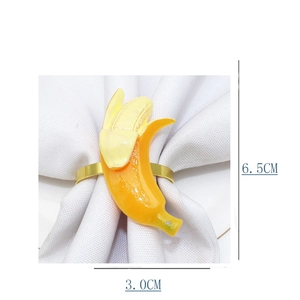 Close-up of banana-shaped napkin ring with dimensions 6.5cm and 3.0cm on white linen