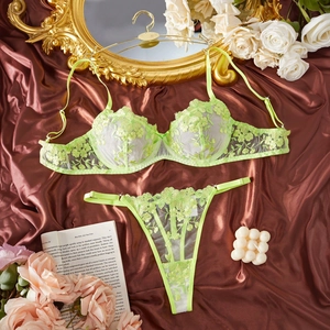 Lace embroidery floral lingerie set in neon green displayed on elegant brown satin