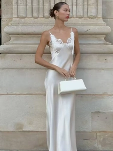 Detailed close-up of white silk maxi dress featuring delicate lace trim on the V-neckline