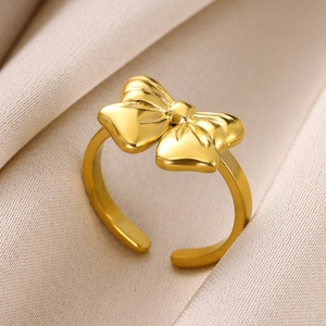 Macro shot of polished gold bow-shaped open ring on premium silk background