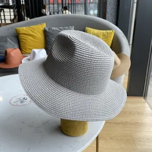 Detail of the woven texture and pinched crown on a grey fedora sun hat for travel