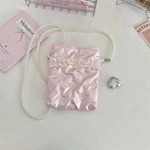 Dettaglio mini borsa rosa in raso con fiocco a rilievo, pizzo e catena di perle