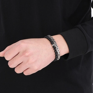Detail of layered men's bracelet with black onyx beads and silver Byzantine chain style